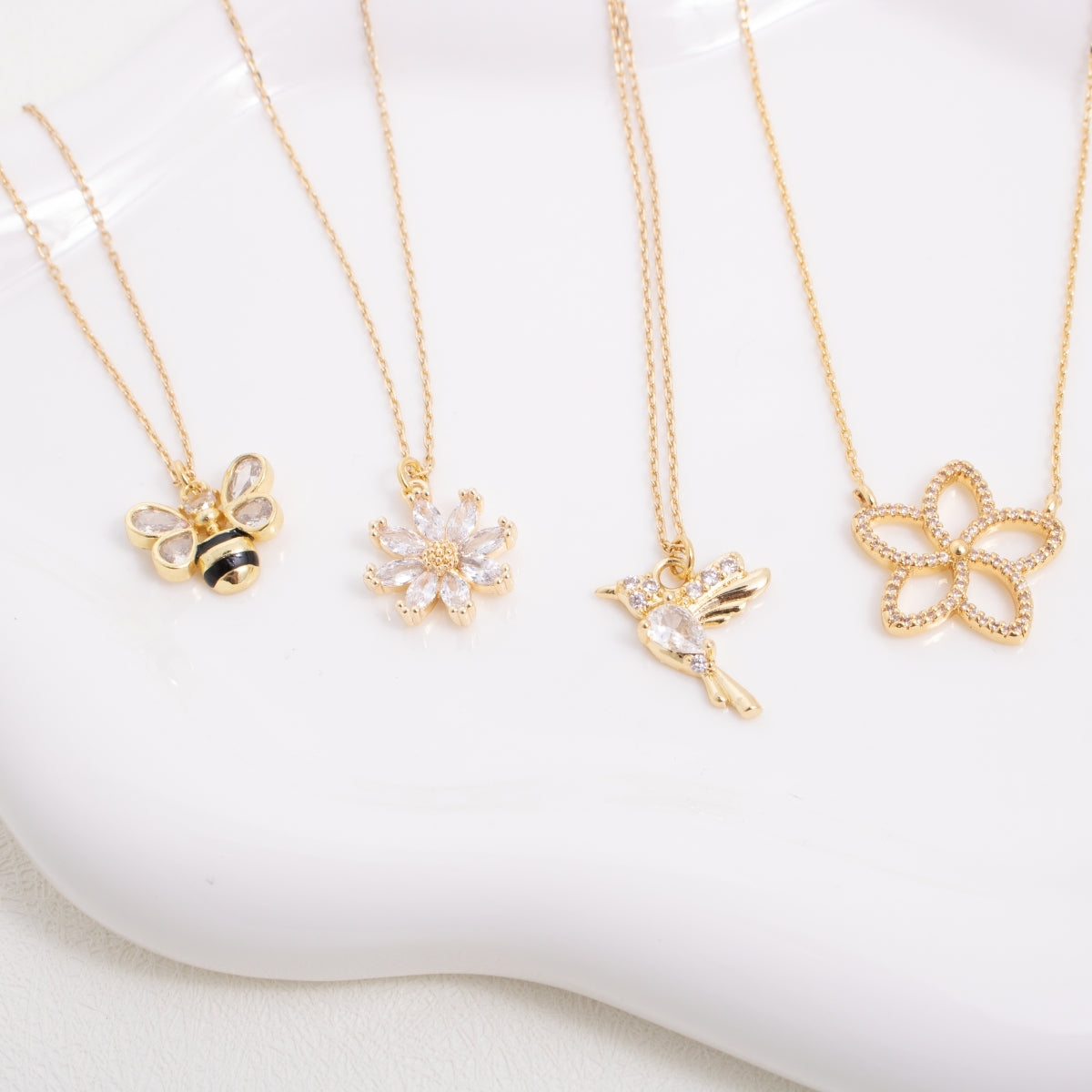 Gold necklaces with various pendants on a white surface