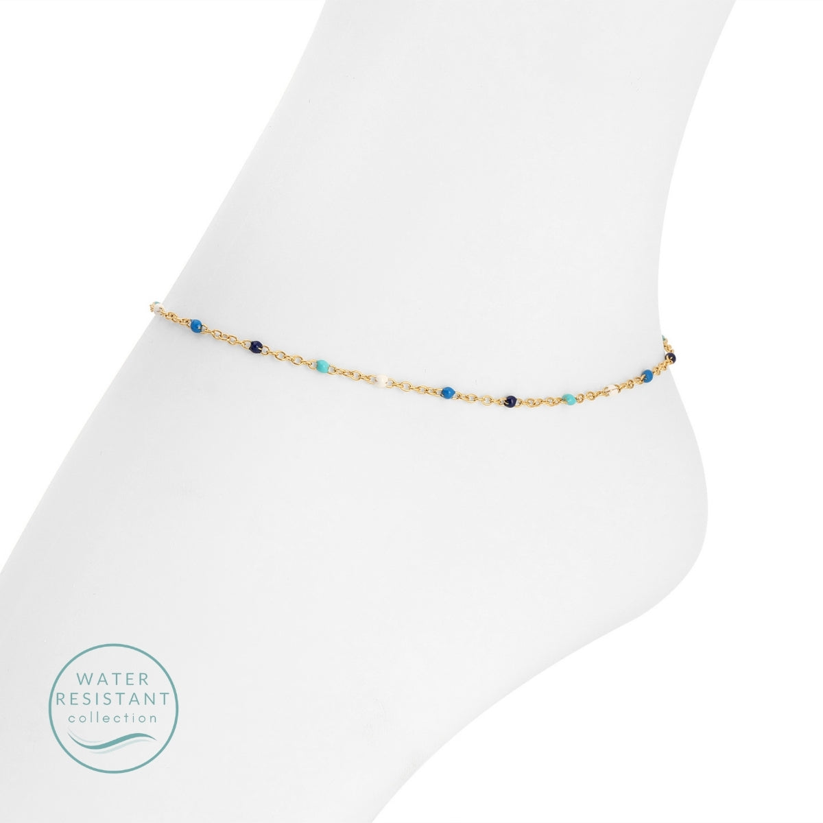 Gold anklet with blue beads on a white foot against a white background