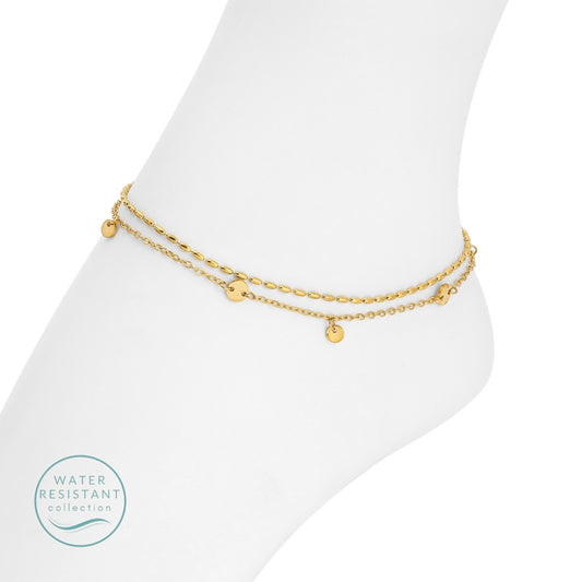 Gold anklets on a white foot with 'Water Resistant' collection label.