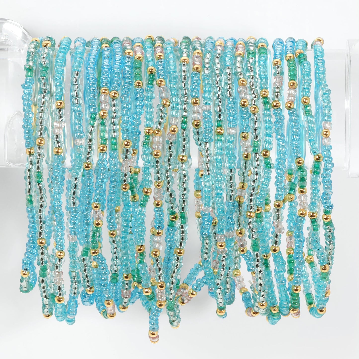 Turquoise and gold beaded bracelets on a white background