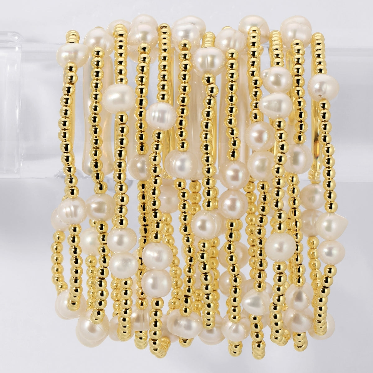 Gold and pearl beaded bracelet on a white background