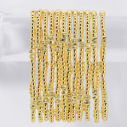 Gold beaded bracelets on a white background