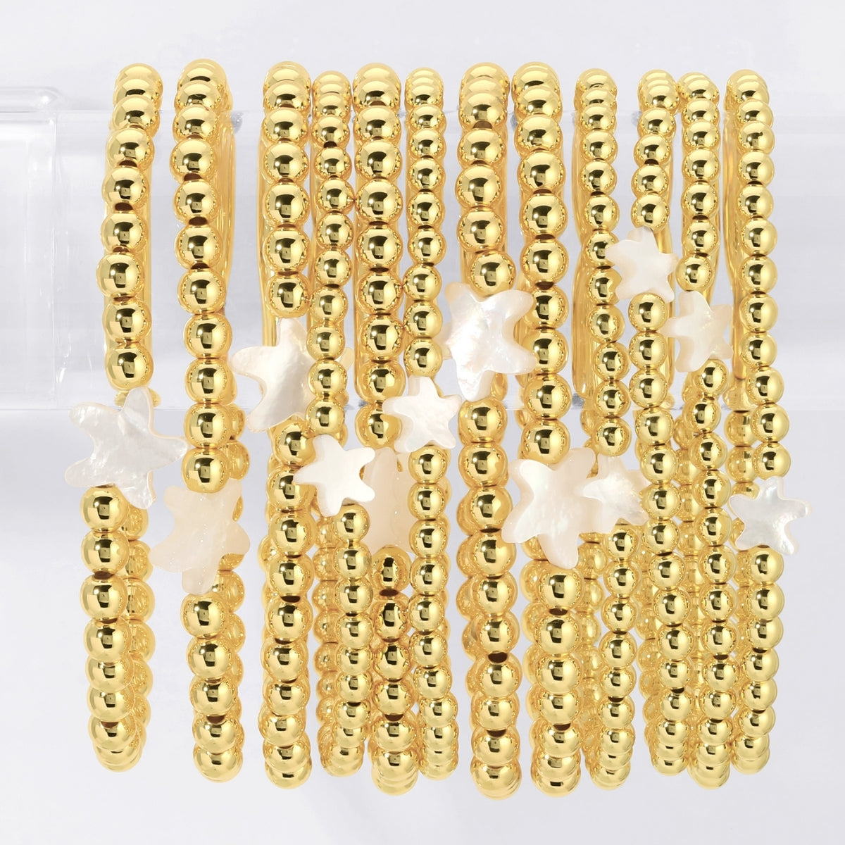 Gold beaded earrings with star accents on a white background