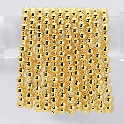 Gold beaded bracelets on a clear background