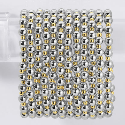 Stack of silver and gold beaded bracelets on a white background