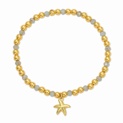 Bracelet with gold beads and a starfish charm on a white background
