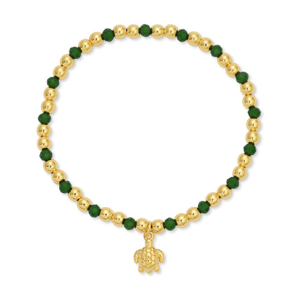 Bracelet with gold beads and a turtle charm on a white background