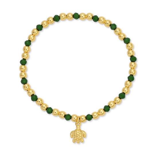 Bracelet with gold beads and a turtle charm on a white background