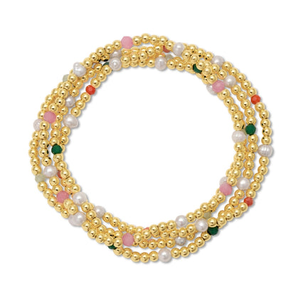 stack of bracelets with gold beads and pearls on a white background