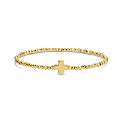 Gold bracelet with a small cross charm on a white background
