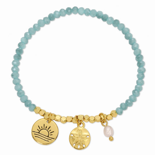 Bracelet with turquoise beads and gold charms on a white background