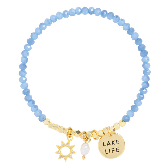 Blue beaded bracelet with gold charms on a white background