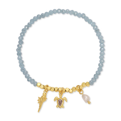 Bracelet with blue beads and gold charms on a white background