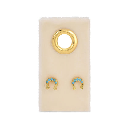 Gold and turquoise earrings on a beige card 