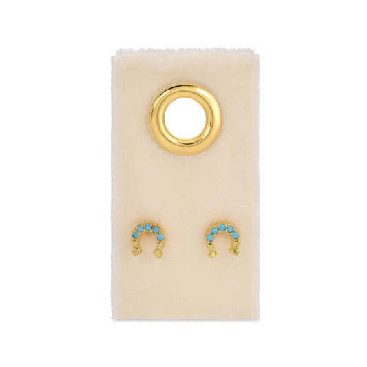 Gold and turquoise earrings on a beige card 