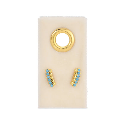 Gold and turquoise earrings on a display card with a gold ring.