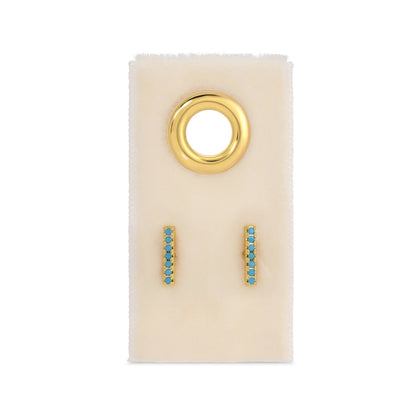 Gold and turquoise earrings on a white card with a gold ring design.