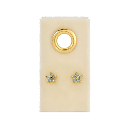Gold star-shaped earrings on a beige card with a gold ring design.