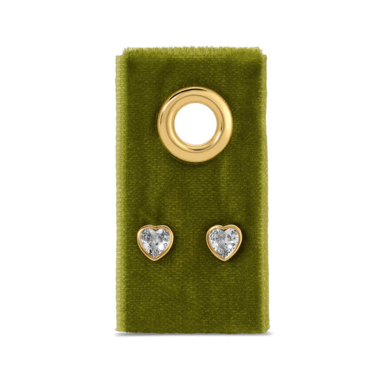 Heart-shaped earrings with clear stones on a green velvet card with a gold ring.