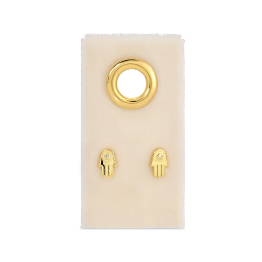 Gold hamsa hand earrings on a white card with a white background