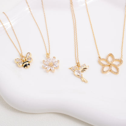 Gold necklaces with various pendants on a white surface