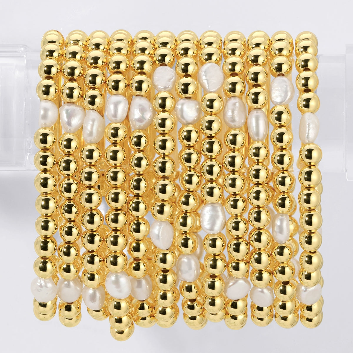 Gold and pearl beaded bracelet on a white background