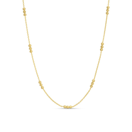 Gold necklace with small beads on a white background