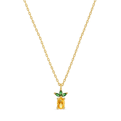 Gold necklace with a pineapple-shaped pendant featuring a yellow gemstone and green accents on a white background.