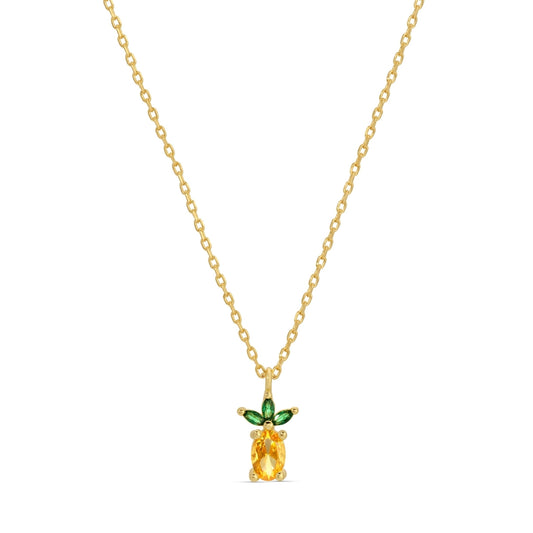 Gold necklace with a pineapple-shaped pendant featuring a yellow gemstone and green accents on a white background.