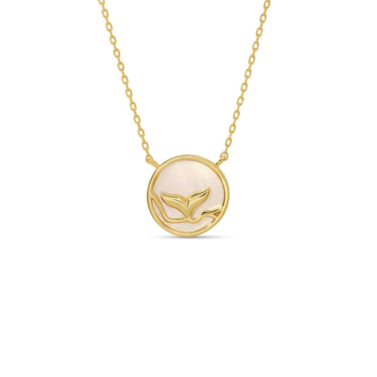 Gold necklace with a circular pendant featuring a whale design on a white background