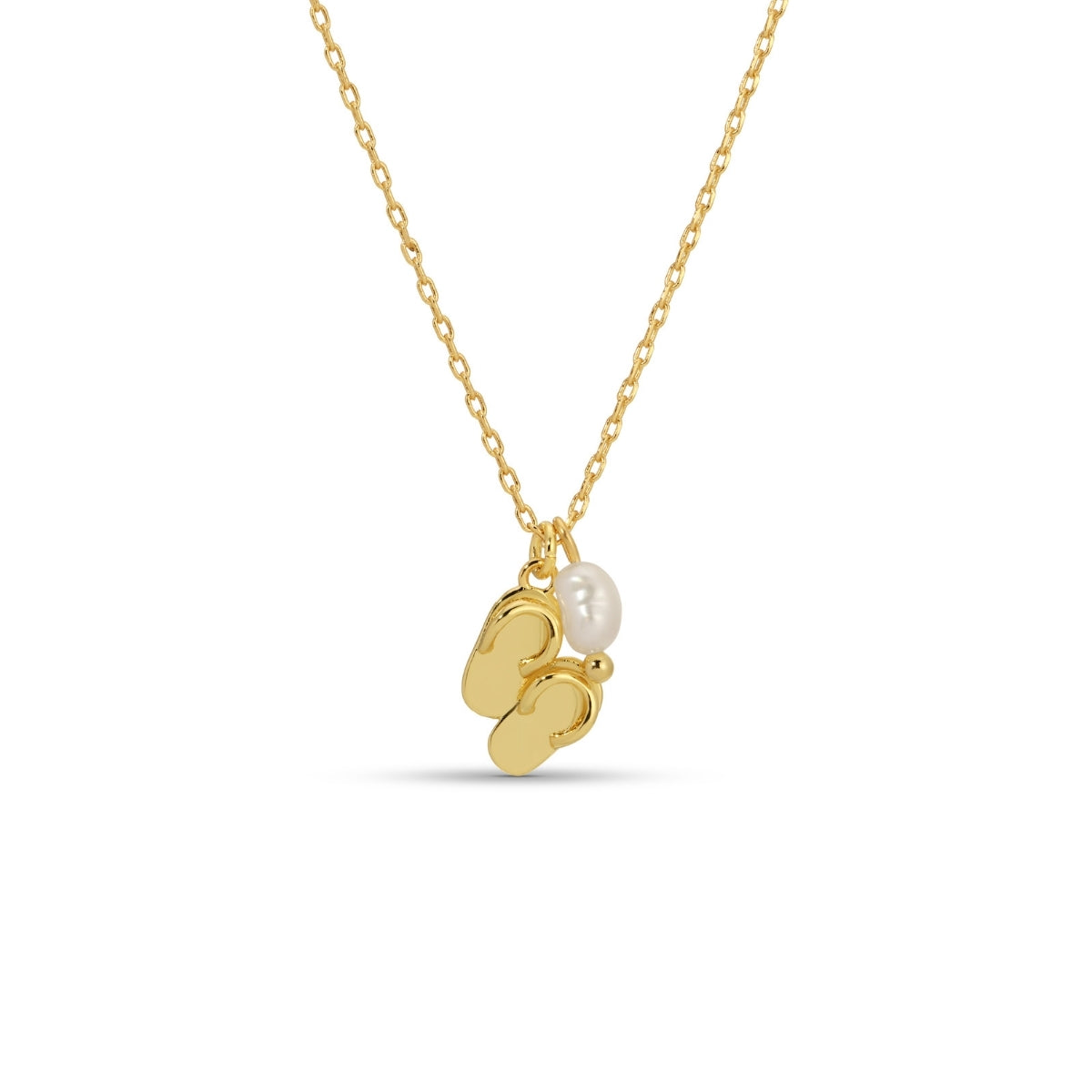 Gold necklace with a small gold flip-flop and pearl pendant on a white background