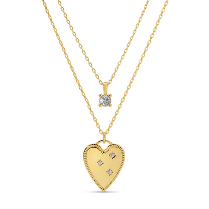 Gold heart-shaped pendant and diamond necklace on a white background