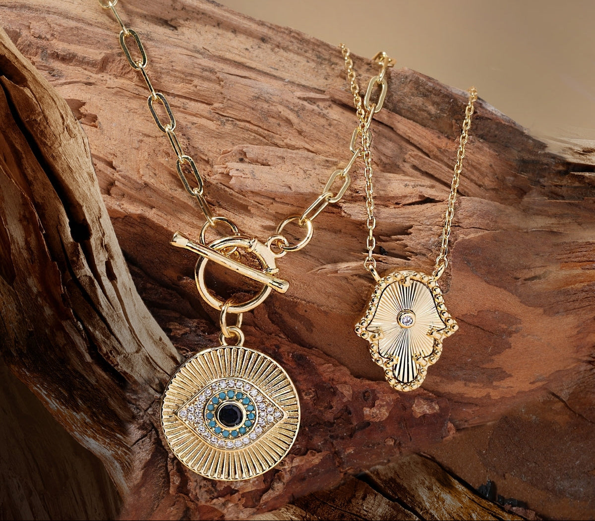 Gold necklace with eye-shaped pendant on a wooden surface