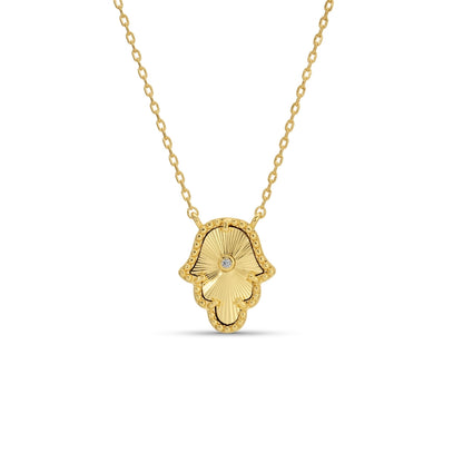 Gold Hamsa hand necklace on a white background