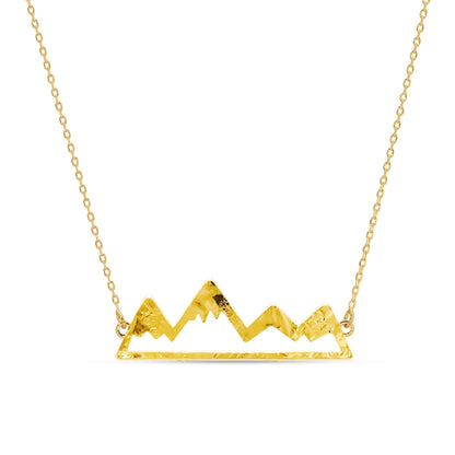 Gold mountain-shaped pendant necklace on a white background
